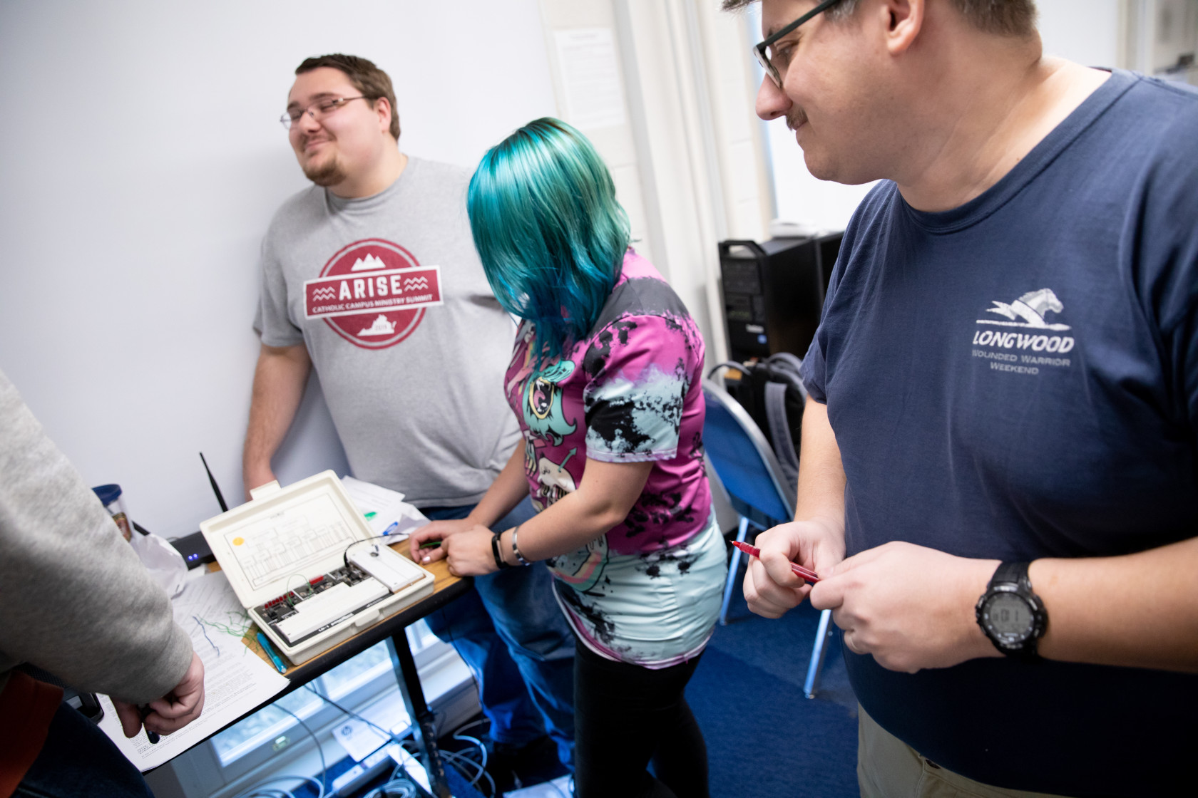 [Students and faculty working with electronics]