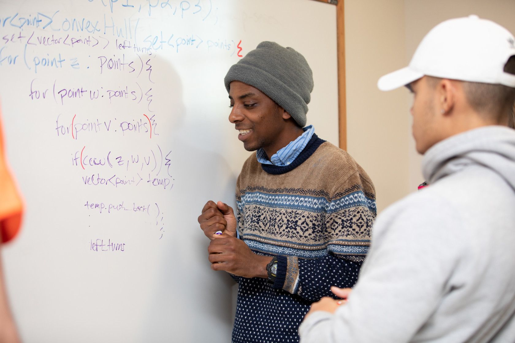 [Student working at a whiteboard to develop an algorithm]